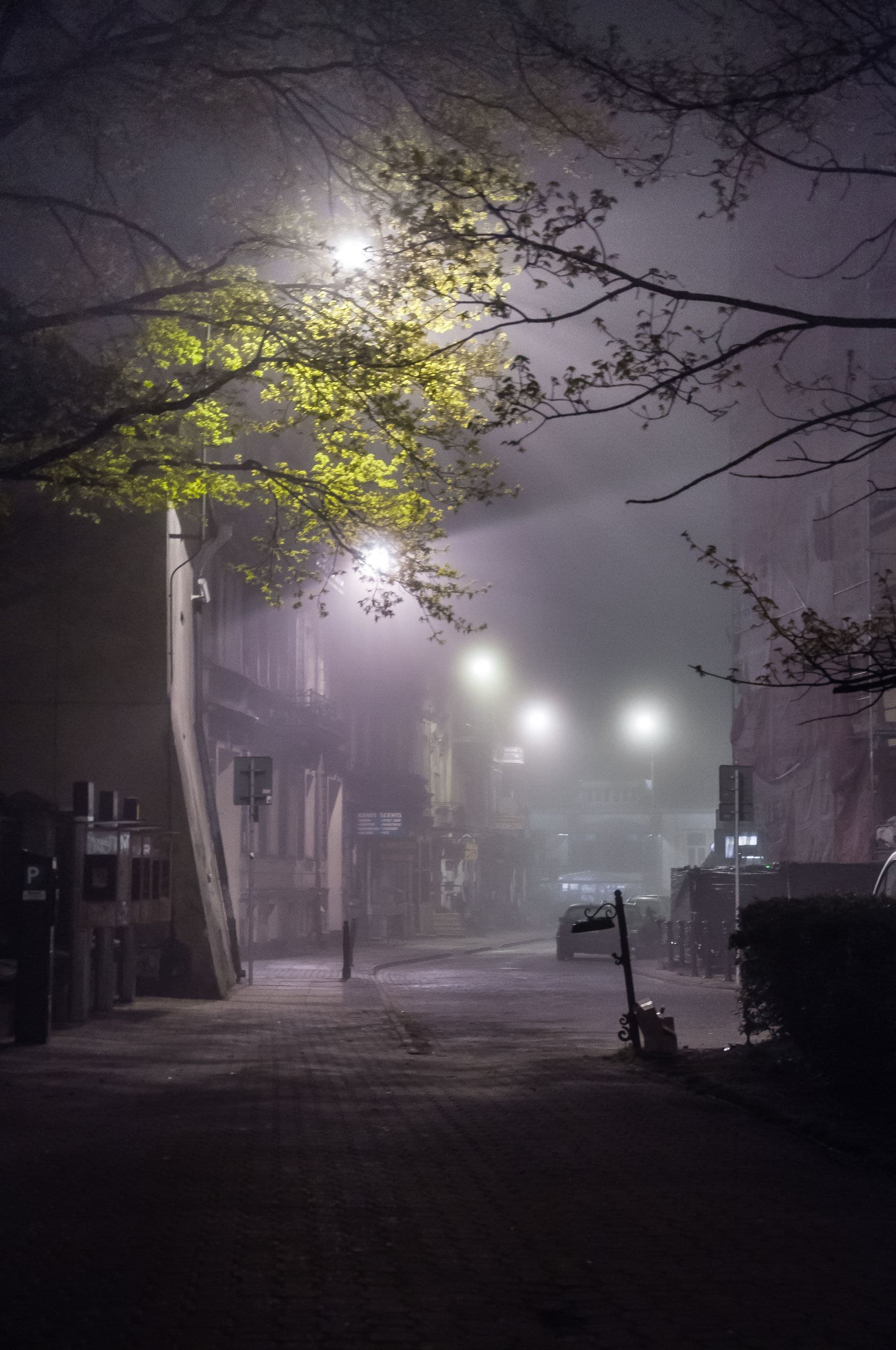 Mistige straat met gloeiende lantaarns